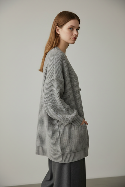 Gray loose knit cardigan sweater, three-quarter back angle on model