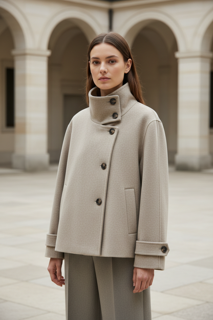 Swiss woman model wearing the light khaki high-collar short winter coat in a museum courtyard