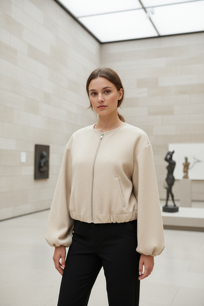 Swiss woman model wearing the pale beige fleece cropped bomber jacket in an art gallery