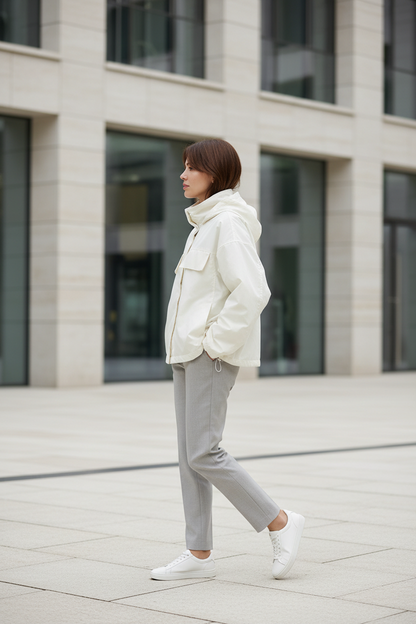 Swiss woman model wearing the beige white hooded nylon windbreaker in a modern Zurich plaza