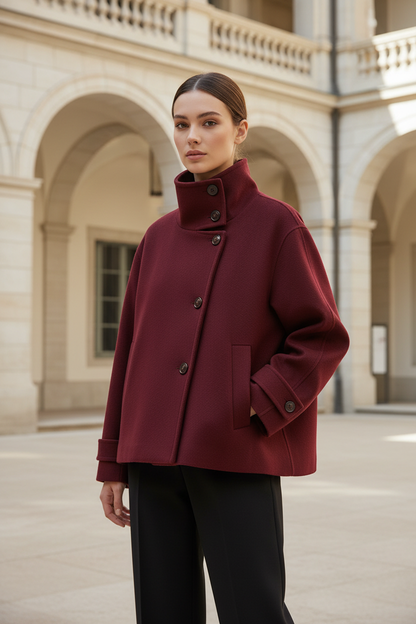 Swiss woman model wearing the burgundy red high-collar short winter coat in a museum courtyard