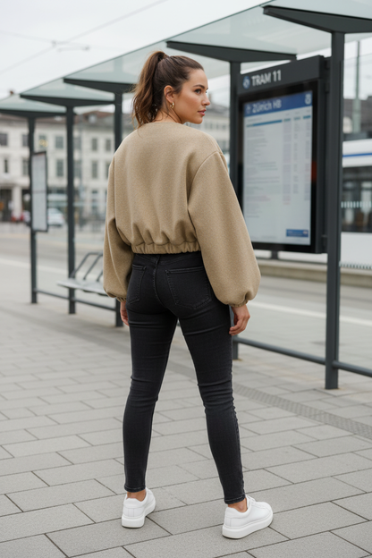 Swiss woman model showing the khaki fleece cropped bomber jacket at a Zurich tram stop