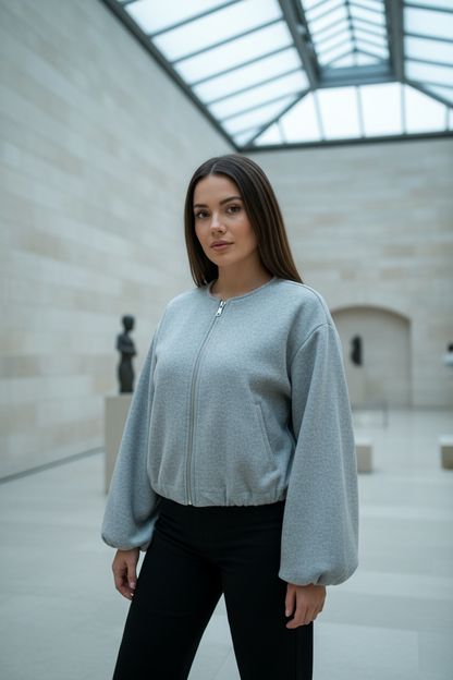 Swiss woman model wearing the gray fleece cropped bomber jacket in an art gallery